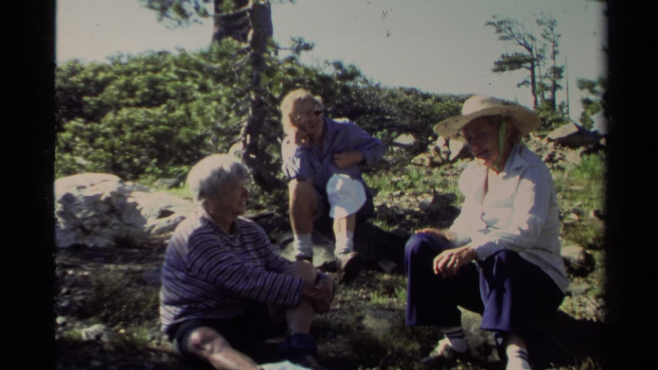 Lake Tahoe 1978 frame with a family group seated in bright sun on rocky terrain, one adult wearing a broad straw hat.