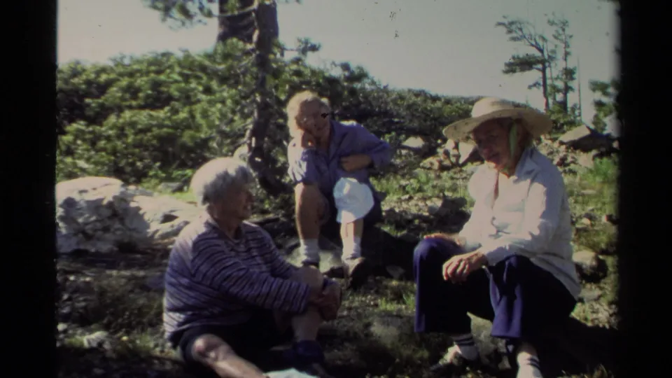 Lake Tahoe 1978 frame with a family group seated in bright sun on rocky terrain, one adult wearing a broad straw hat.