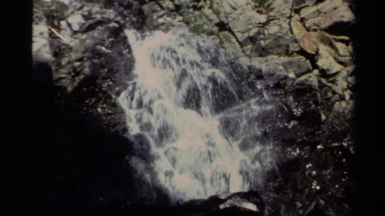 1978 8mm Lake Tahoe footage showing water falling through rugged rocks in bright daylight.