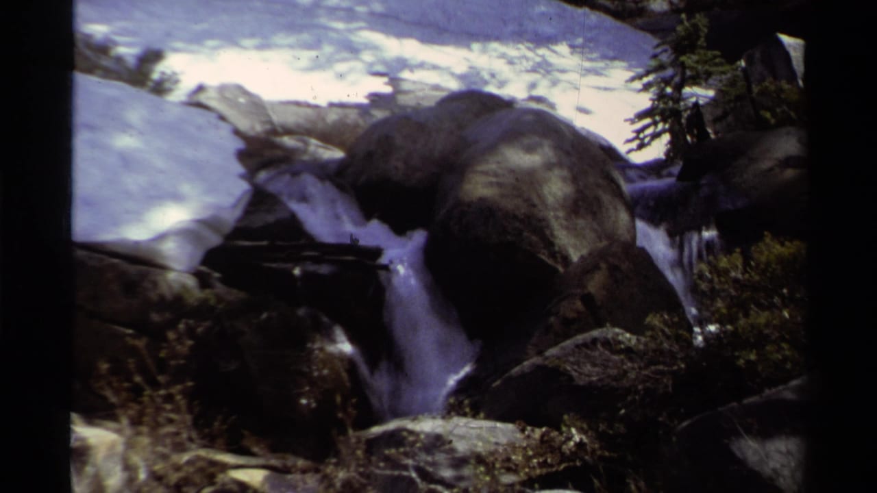 Lake Tahoe mountain stream scene with boulders, snow, and a small cascade visible in 1978 8mm footage.