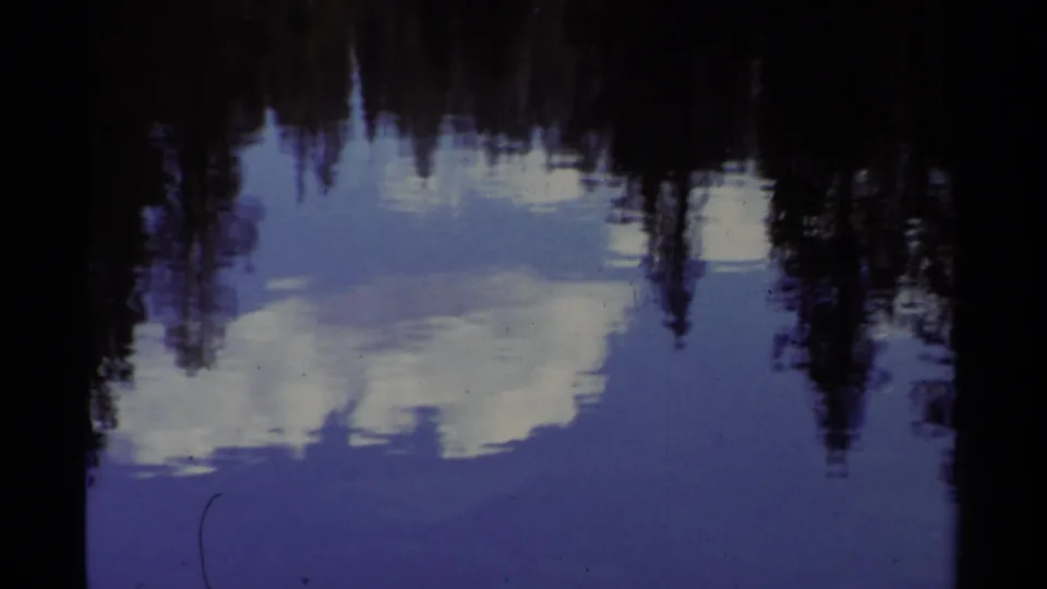 The final frame holds on rippled Lake Tahoe water, where white clouds and dark treeline silhouettes reflect across the surface.