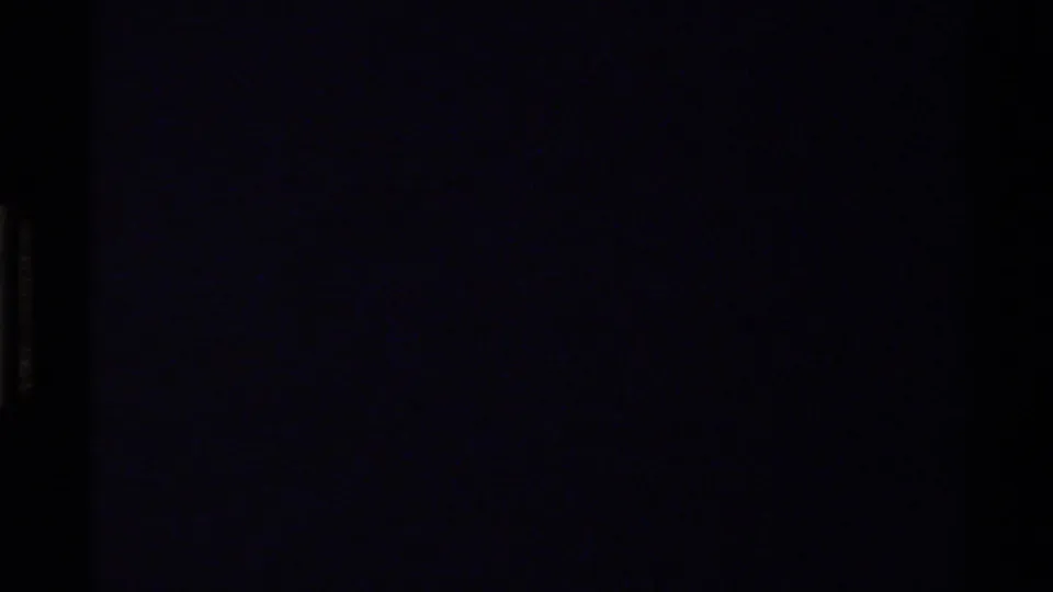End frame from the 1978 8mm clip, mostly dark with faint blue-purple film tone and little visible scene detail.