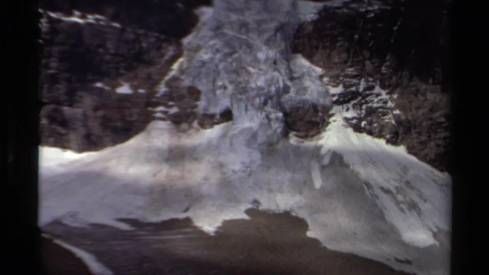 1979 British Columbia 8mm frame showing a glacier and snowfield flowing down a rugged rocky slope.