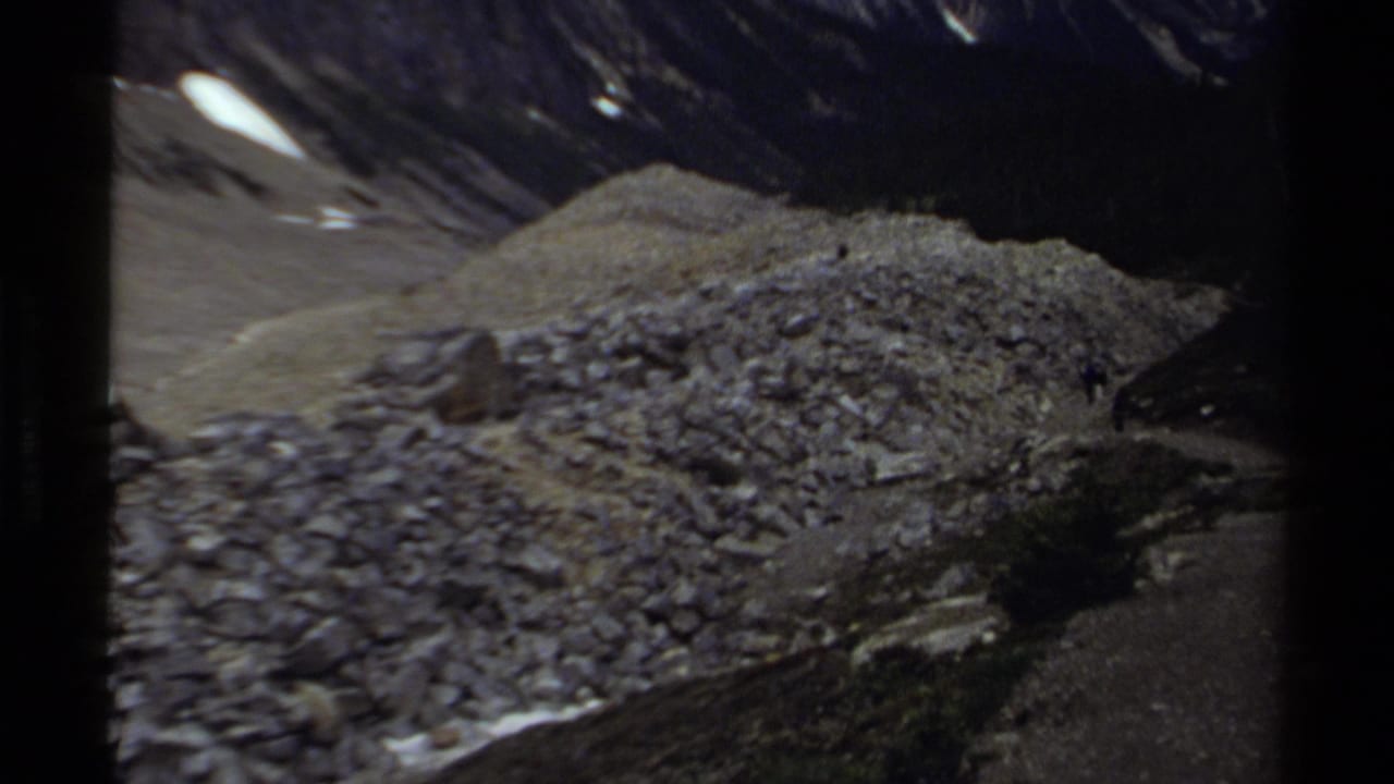 Scree-covered mountain ridge with a small distant figure near the right edge.