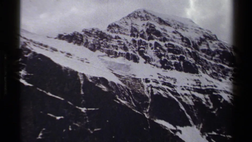 1979 British Columbia frame showing a snow-streaked rocky peak under muted, overcast light.