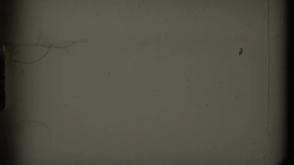 1979 8mm British Columbia travel footage begins with a partial dark frame and a distant view of mountains, water, and cloudy sky.