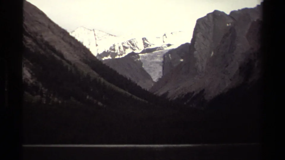 1979 British Columbia 8mm view of snow-bright peaks and a pale glacier-like snowfield between shadowed mountain walls.