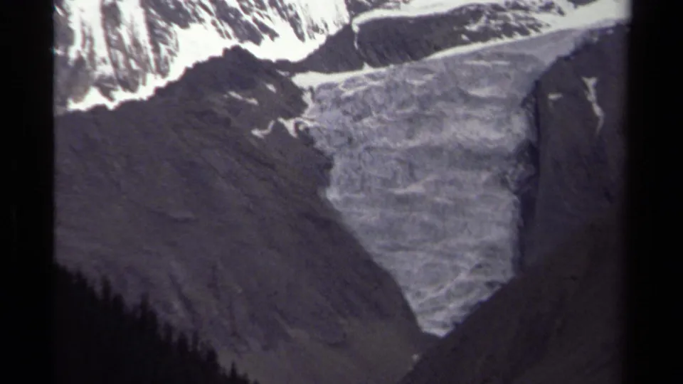 1979 British Columbia 8mm frame with a close view of the glacier, snowy upper ridge, and shadowed mountain sides.