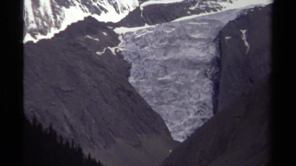 1979 8mm view of a glacier descending between rugged British Columbia mountain slopes under muted light.