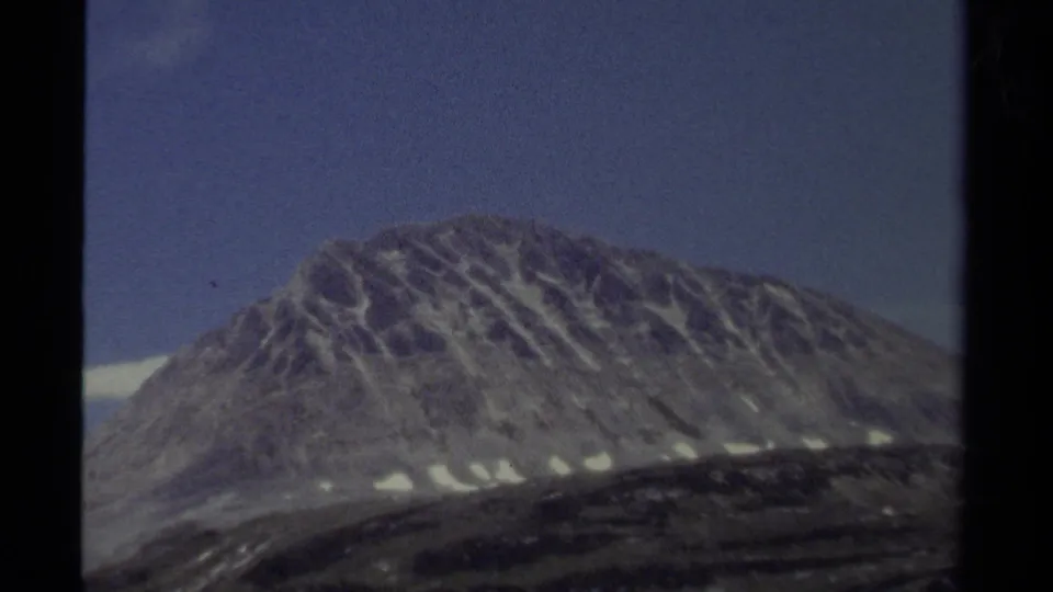 1979 British Columbia 8mm landscape with a broad mountain slope, blue sky, and traces of snow.