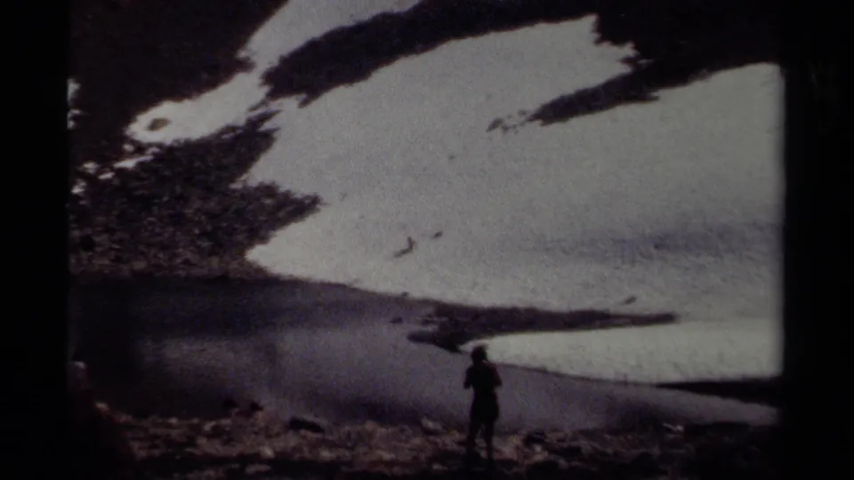 A silhouetted person appears at the lower edge of a snowy alpine slope in 1979 British Columbia home-movie footage.