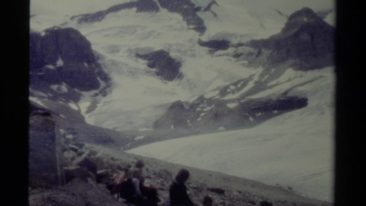 1979 British Columbia home-movie view of hikers at the base of a broad snow-covered alpine landscape.