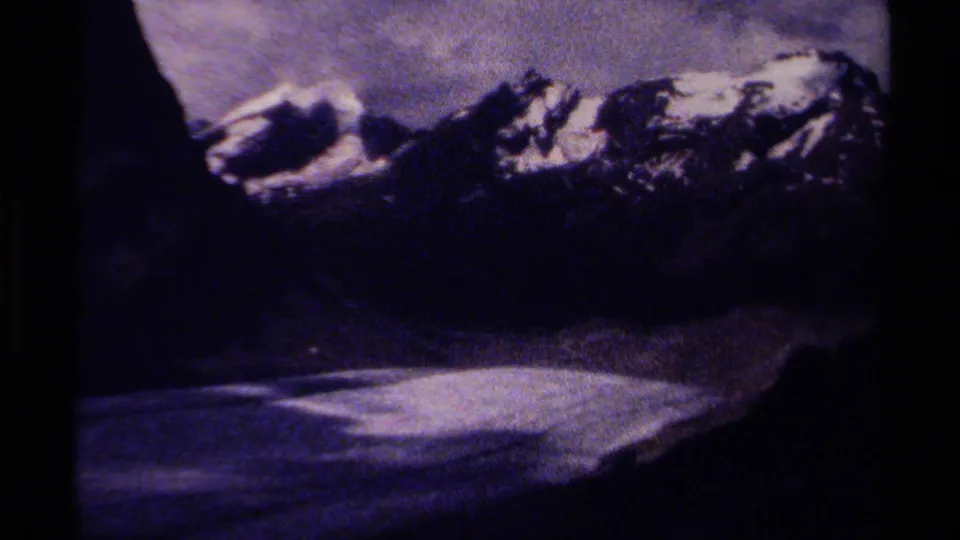 1979 British Columbia 8mm frame holding on snow-streaked mountain ridges above a pale glacial valley or snowfield.