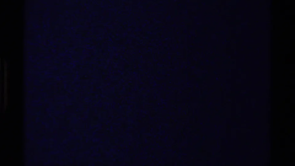 End frame from the 1979 British Columbia 8mm clip, mostly dark with blue-black grain and little visible landscape detail.