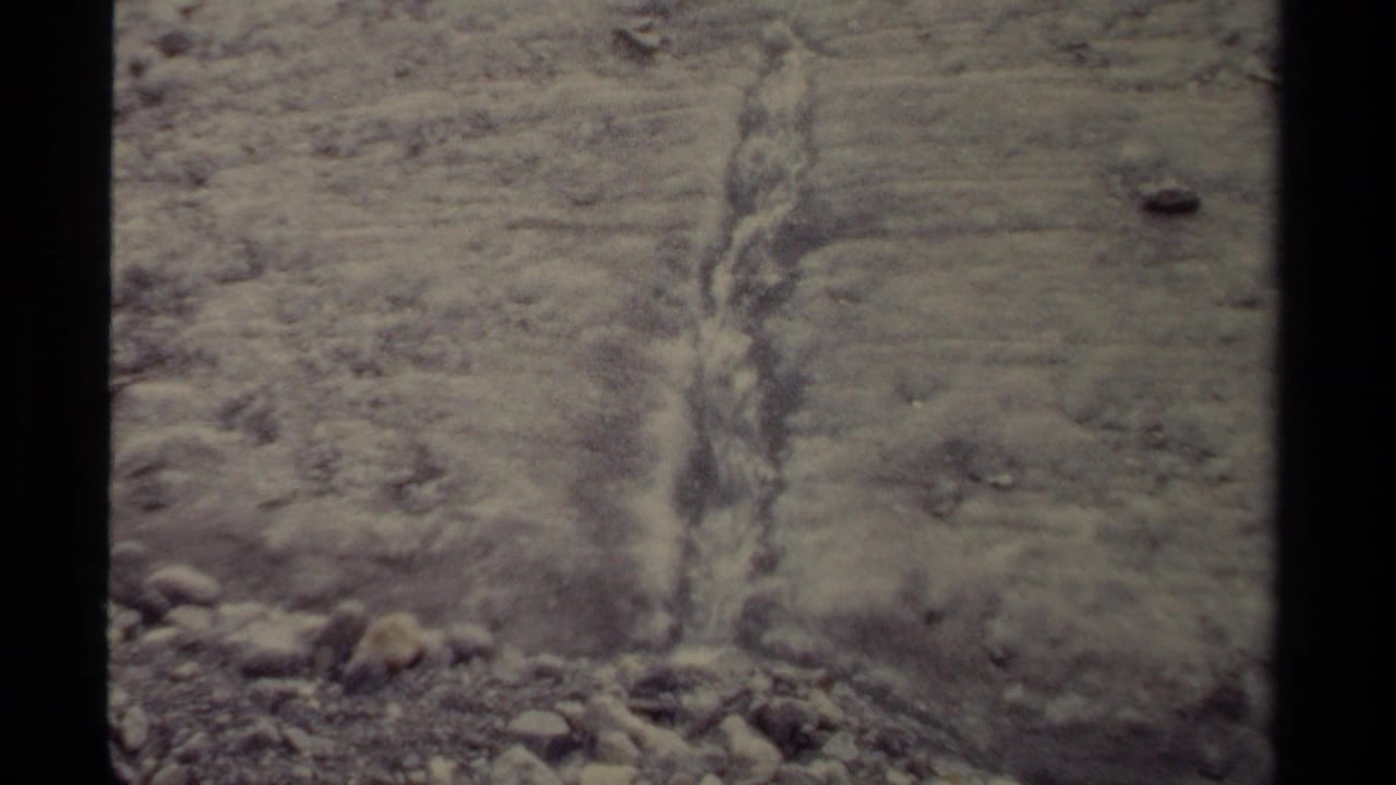 Close 8mm view of meltwater cutting down a rocky slope in British Columbia glacier terrain, 1979.