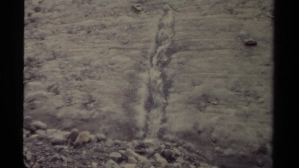 Close 8mm view of meltwater cutting down a rocky slope in British Columbia glacier terrain, 1979.
