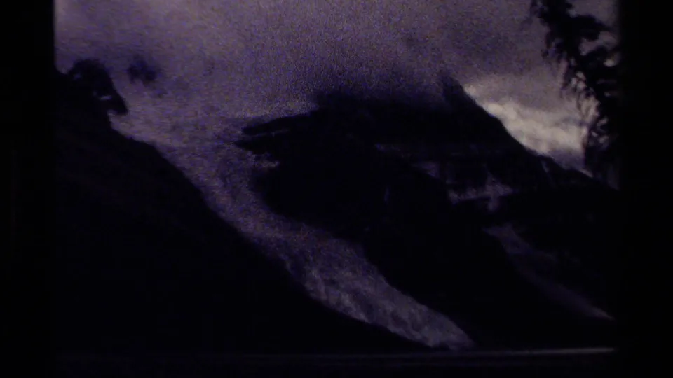Moody 8mm view of a glacier descending below a misty snow-capped mountain in British Columbia, 1979.