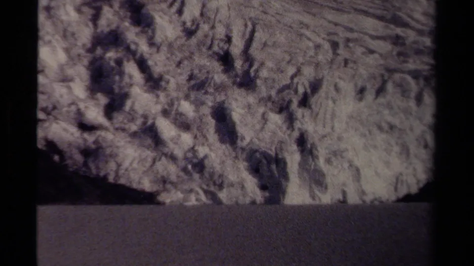 British Columbia 1979 home-movie frame showing rough stone detail and a dark foreground strip, likely filmed from a roadside viewpoint.