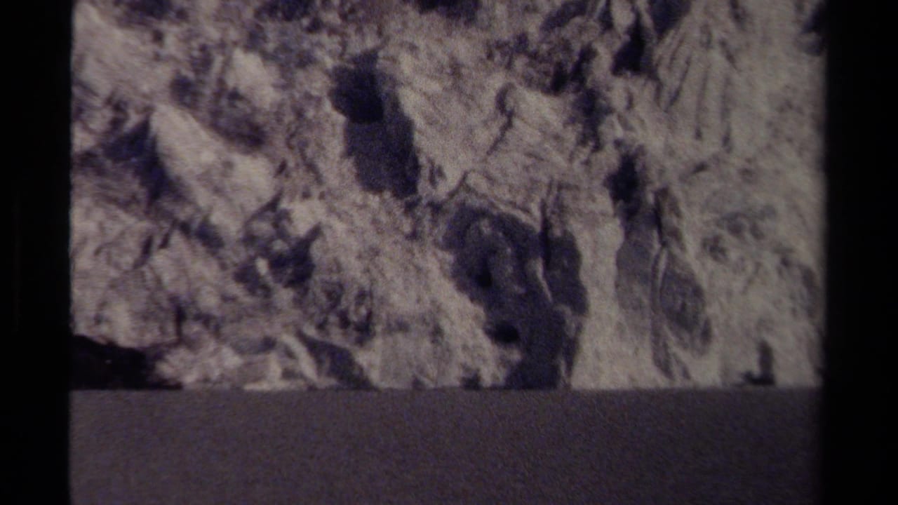 Close view of icy textured cliff above a dark horizontal band.