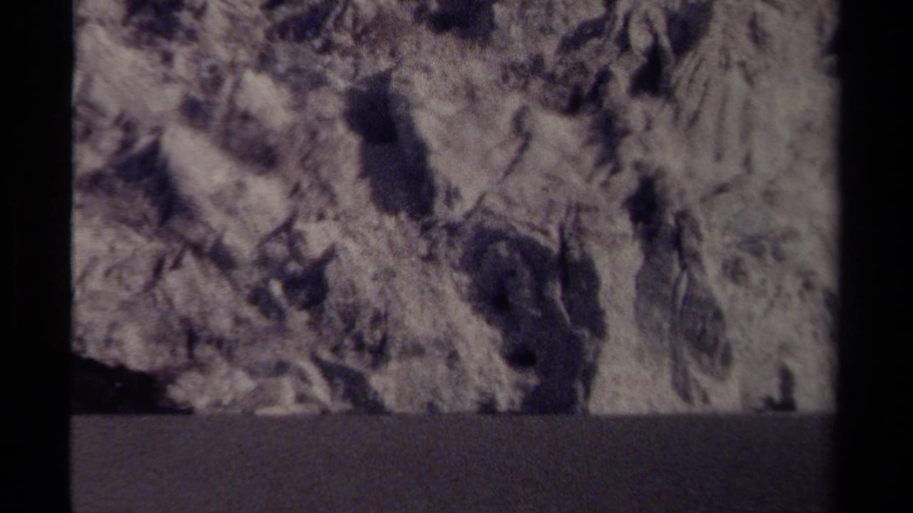 Icy rock formations and dark crevices above a shadowed lower band.