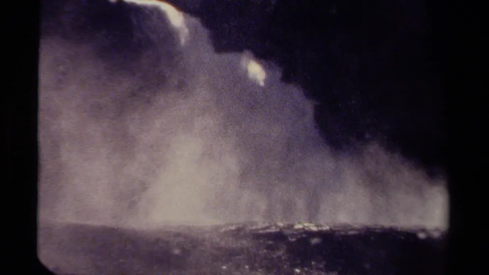 1979 British Columbia travel footage frame with dense waterfall spray, dark framing, and visible 8mm grain.