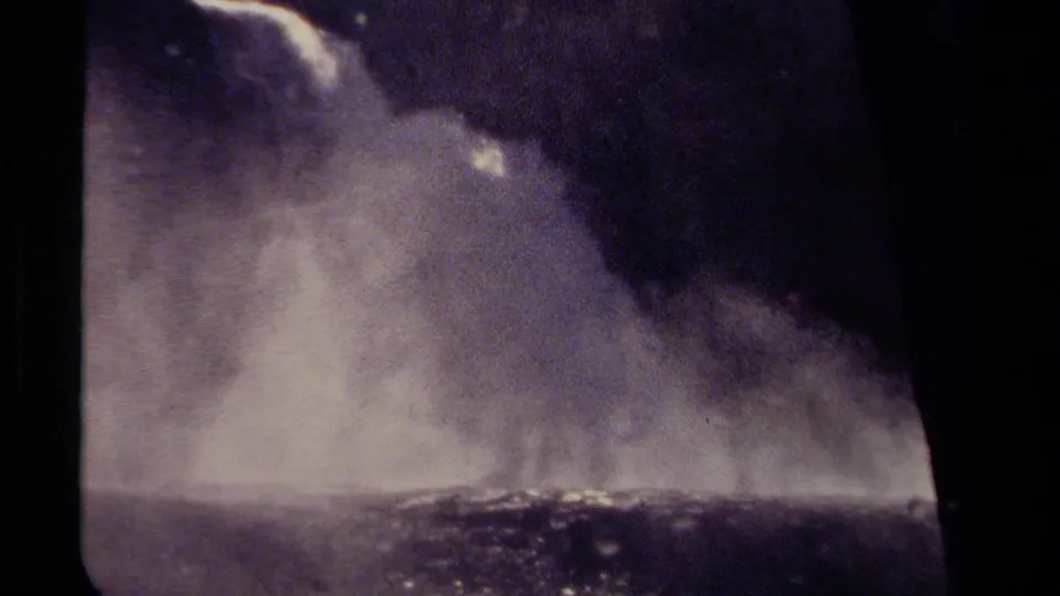 Vintage 8mm British Columbia frame showing waterfall spray and a dark window-like edge around the view.
