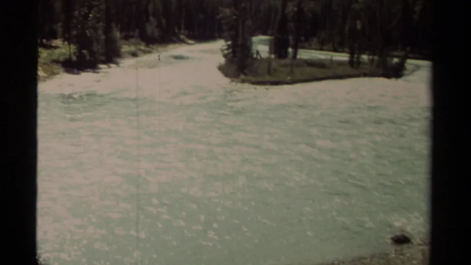 Late-1970s 8mm frame of Moose River rushing between snowy banks and evergreen trees in British Columbia.
