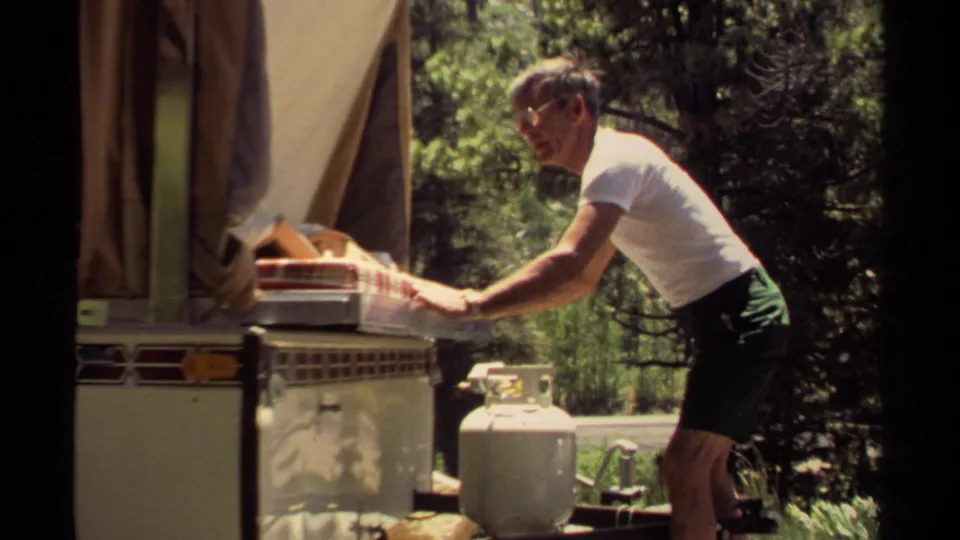 At the end of the clip, the man extends both arms to guide the bedding back into the camper trailer in Mendocino.