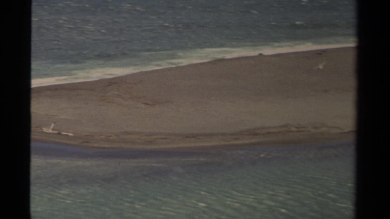 1980 Mendocino coastal view showing surf, sand, and a water channel within the edges of an 8mm frame.