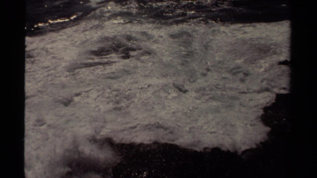 Foamy Pacific surf surges across dark coastal rock in the 1980 Mendocino home-movie footage.