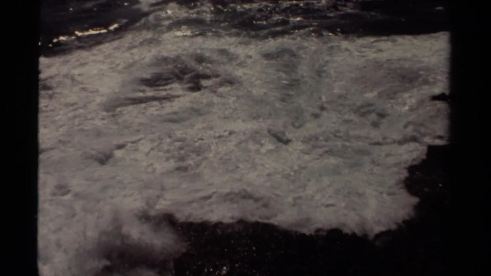 Foamy Pacific surf surges across dark coastal rock in the 1980 Mendocino home-movie footage.