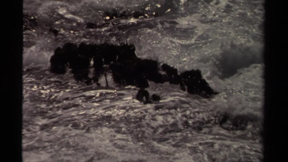 Mendocino, California coastal surf breaks over dark rocks in grainy 1980 8mm home-movie footage.
