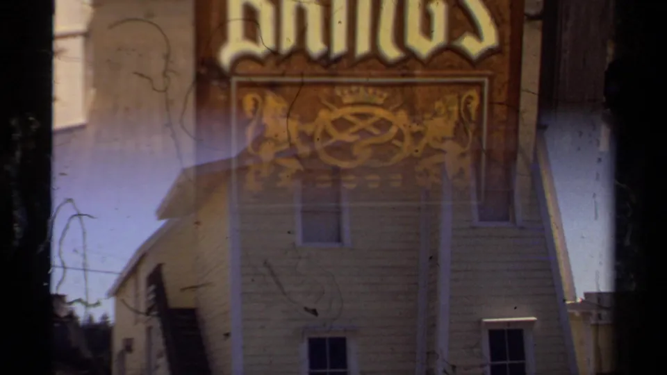 Mendocino 1980 frame with a pastries sign partly superimposed over a yellow shingled building and dark film-frame borders.
