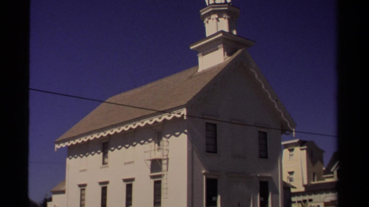 Mendocino church exterior in 1980, showing the white facade, steep roof, cupola base, blue sky, and overhead wire.