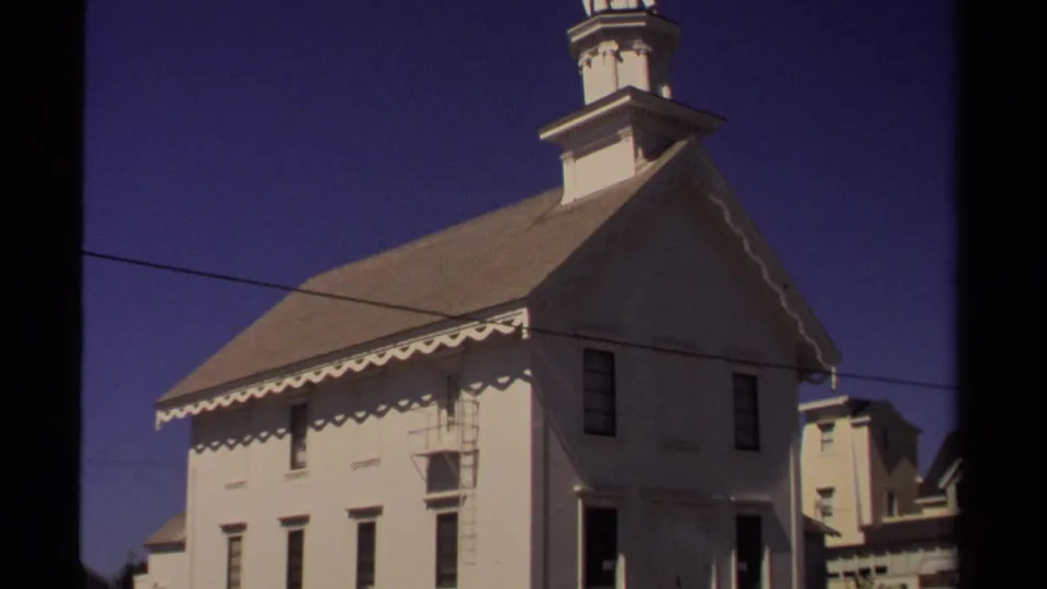 Mendocino church exterior in 1980, showing the white facade, steep roof, cupola base, blue sky, and overhead wire.