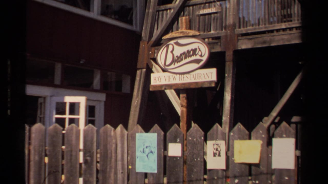 Brennan's Bay View Restaurant sign, balcony, fence, and posters on a wooden facade.