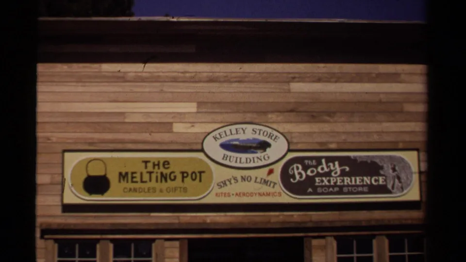Mendocino shopfront signage appears on a wooden building, including The Melting Pot, Kelley Store Building, Sky's No Limits, and The Body Experience.