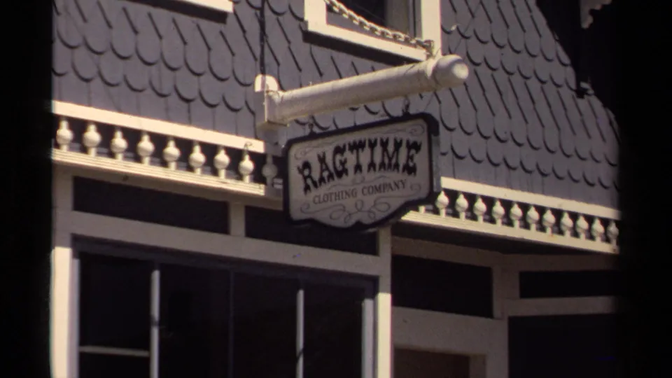 Mendocino storefront detail showing a projecting Ragtime Clothing Company sign beneath decorative trim.