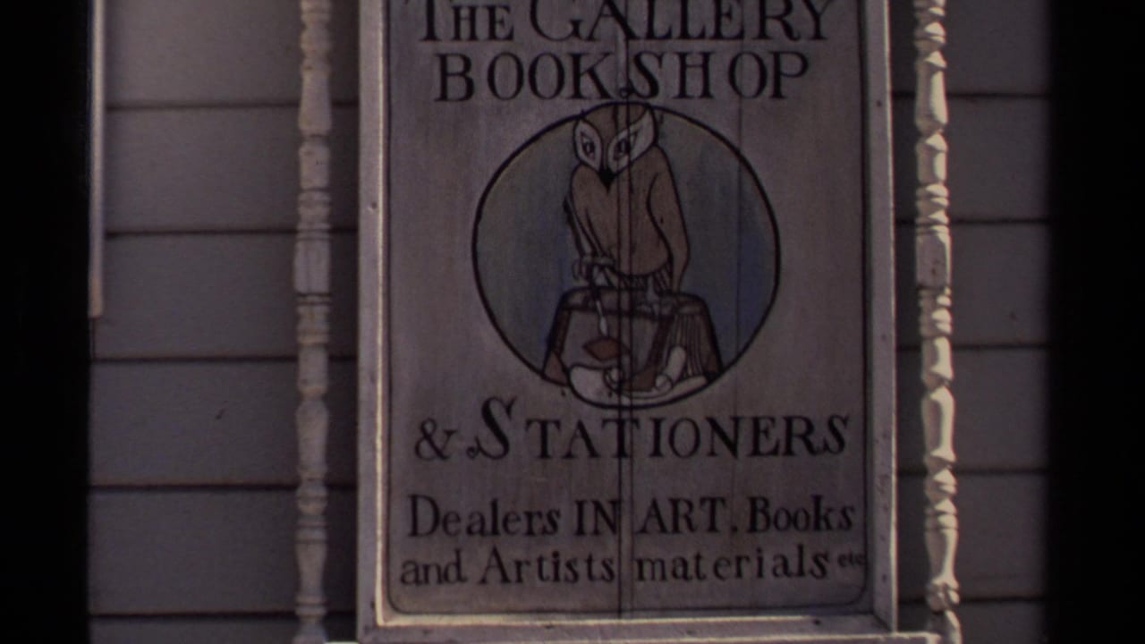 1980 Mendocino footage frame showing The Gallery Bookshop and Stationers sign with owl artwork and art-supplies text on a wooden storefront.