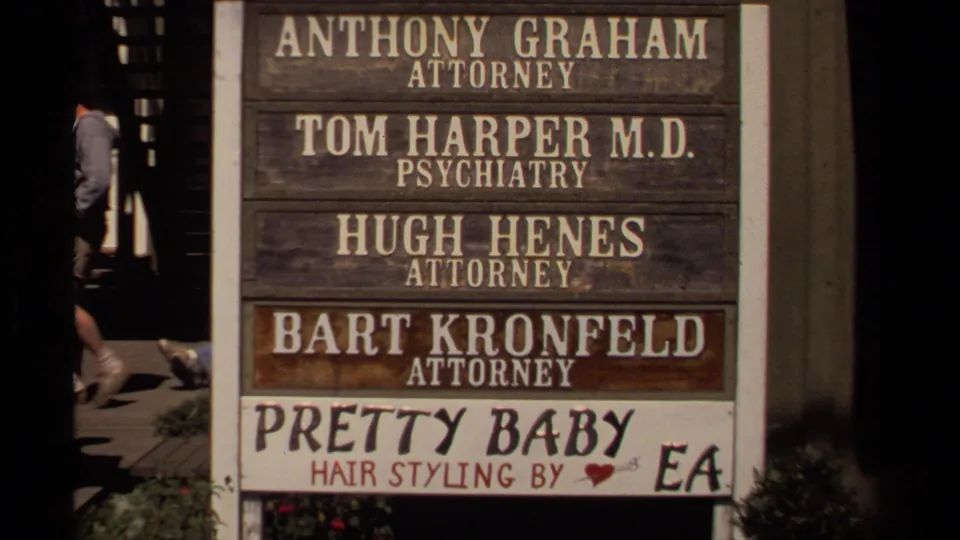 1980 Mendocino frame centered on a weathered directory board naming local attorneys, a psychiatrist, and a hair-styling business.