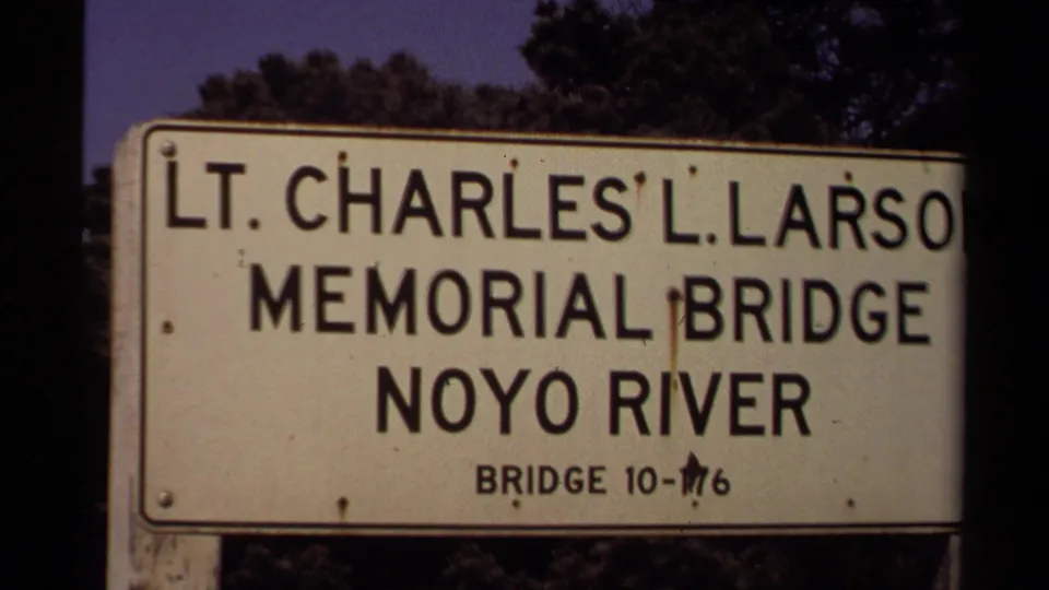 Cropped 1980 8mm frame of the Lt. Charles L. Larson Memorial Bridge sign, with Noyo River text visible.