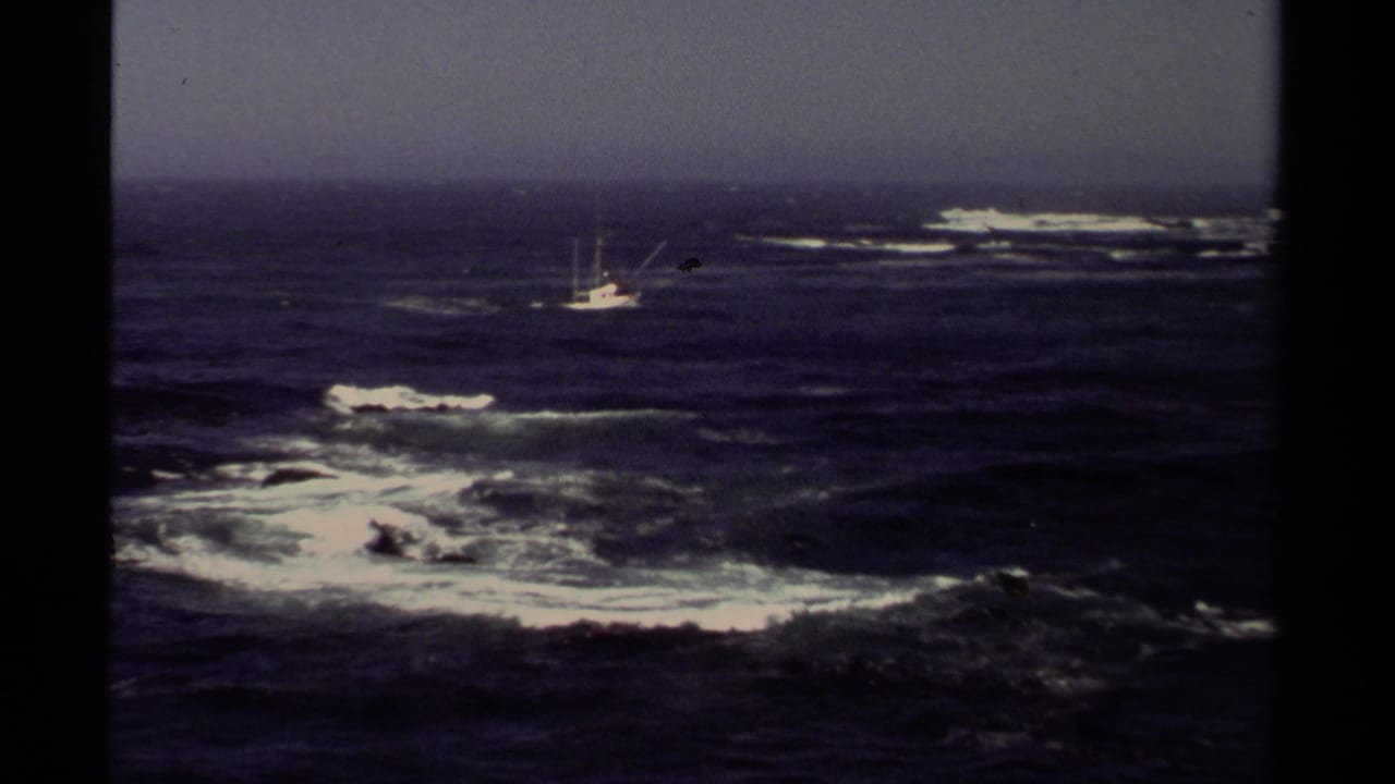Small fishing boat offshore amid dark waves and white surf.