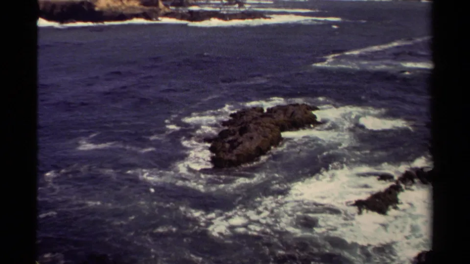 Mendocino coastal water and an offshore rock outcrop appear in a steady 1980 8mm frame.