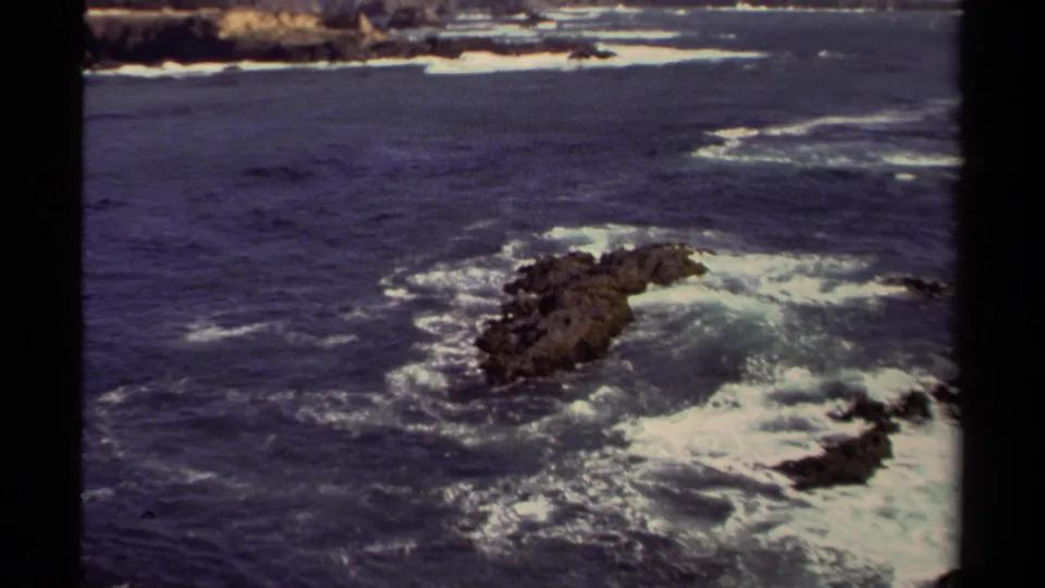 Final frame shows Mendocino ocean surf breaking around dark rocks with visible 8mm film borders.