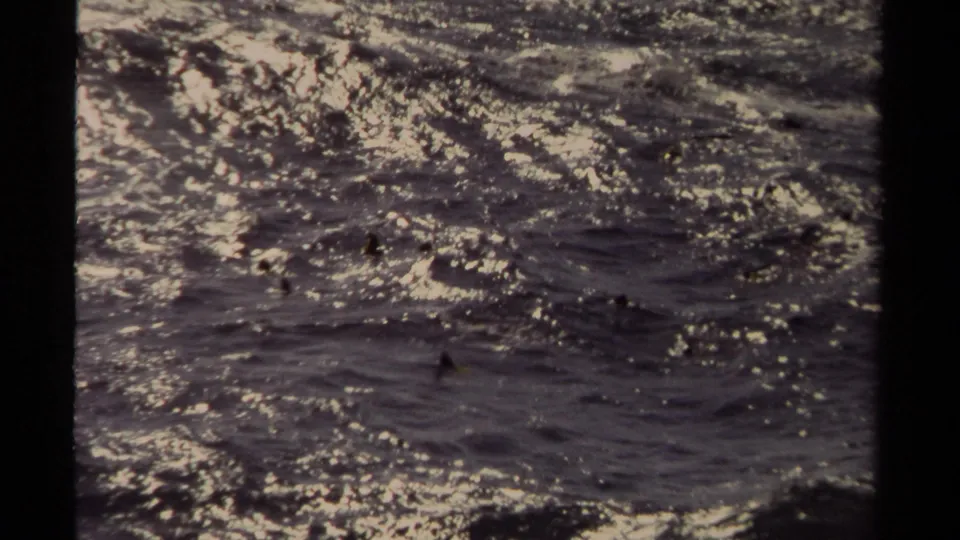1980 8mm Mendocino footage showing turbulent water rippling across the frame with shimmering highlights and grain.