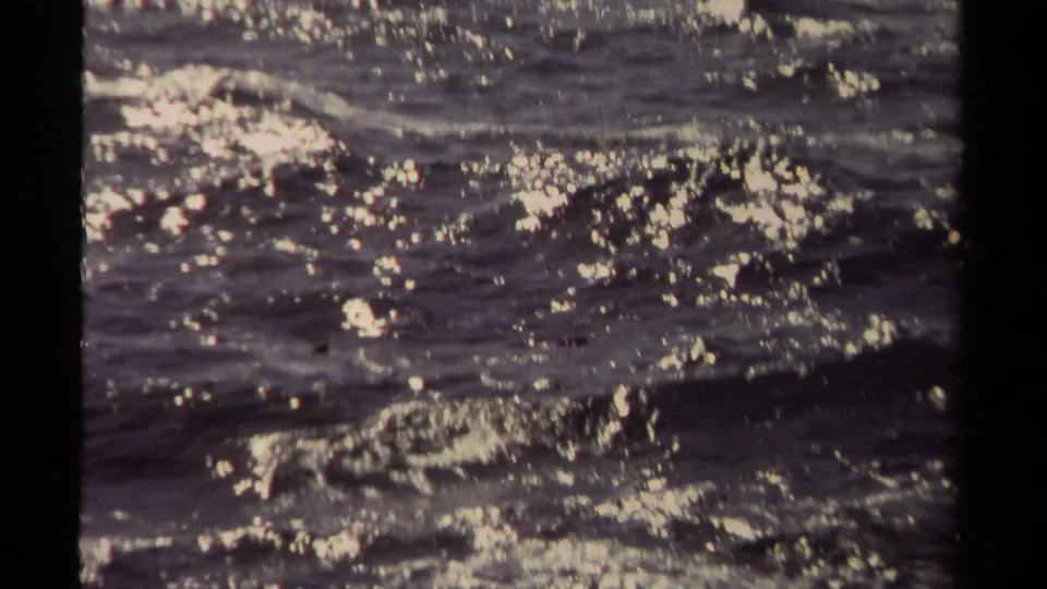 Mendocino 1980 frame with shimmering highlights over dark ocean waves and foam patches.