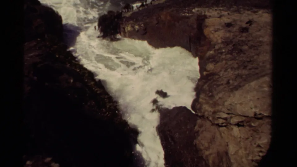 1980 Mendocino, California 8mm frame showing turbulent white water confined by dark cliffs and tan rock ledges.