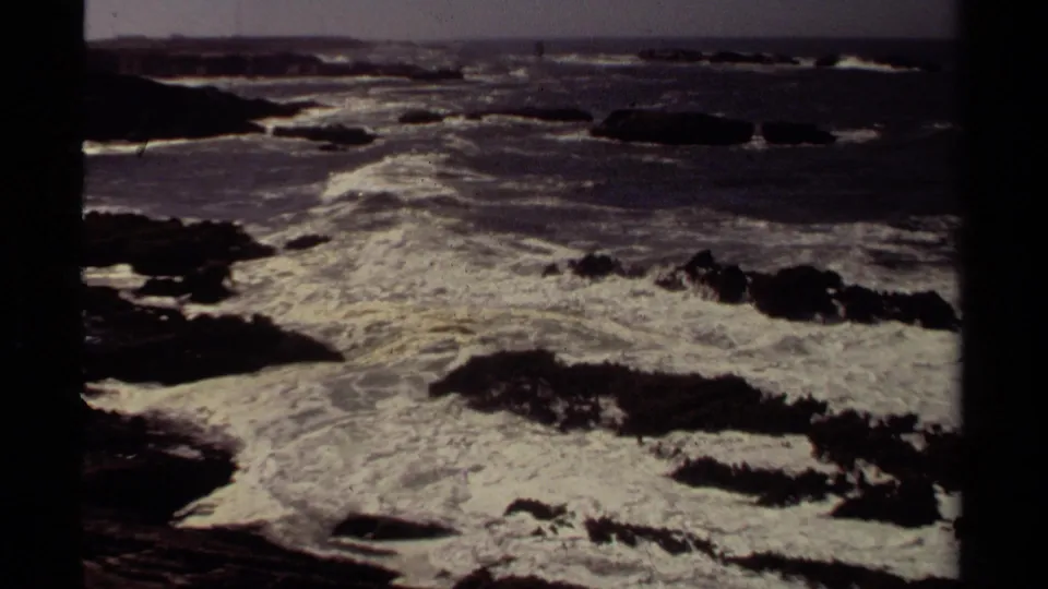Vintage 8mm frame of white Pacific surf breaking over low rocks on the Mendocino shoreline.