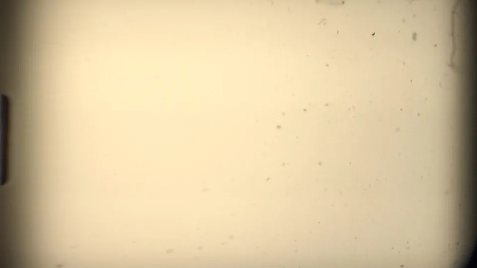 Blank or overexposed-looking 8mm film area with warm tint, dust specks, and dark gate edges in the supplied 1980 Mendocino clip.