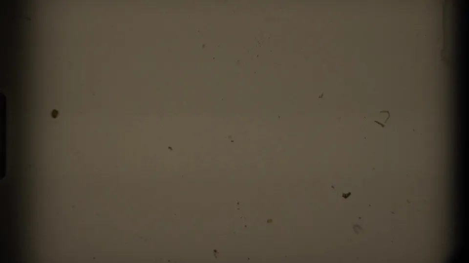 Muted 8mm frame from the supplied Mendocino 1980 metadata, showing film dust, scratches, and dark gate edges rather than a clear landscape.